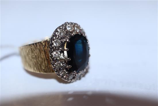 A 1960s textured 18ct gold, sapphire and diamond oval cluster ring, size L.
